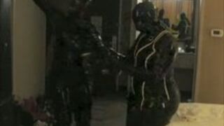 Two Girls in Rubber Wearing Gas Masks